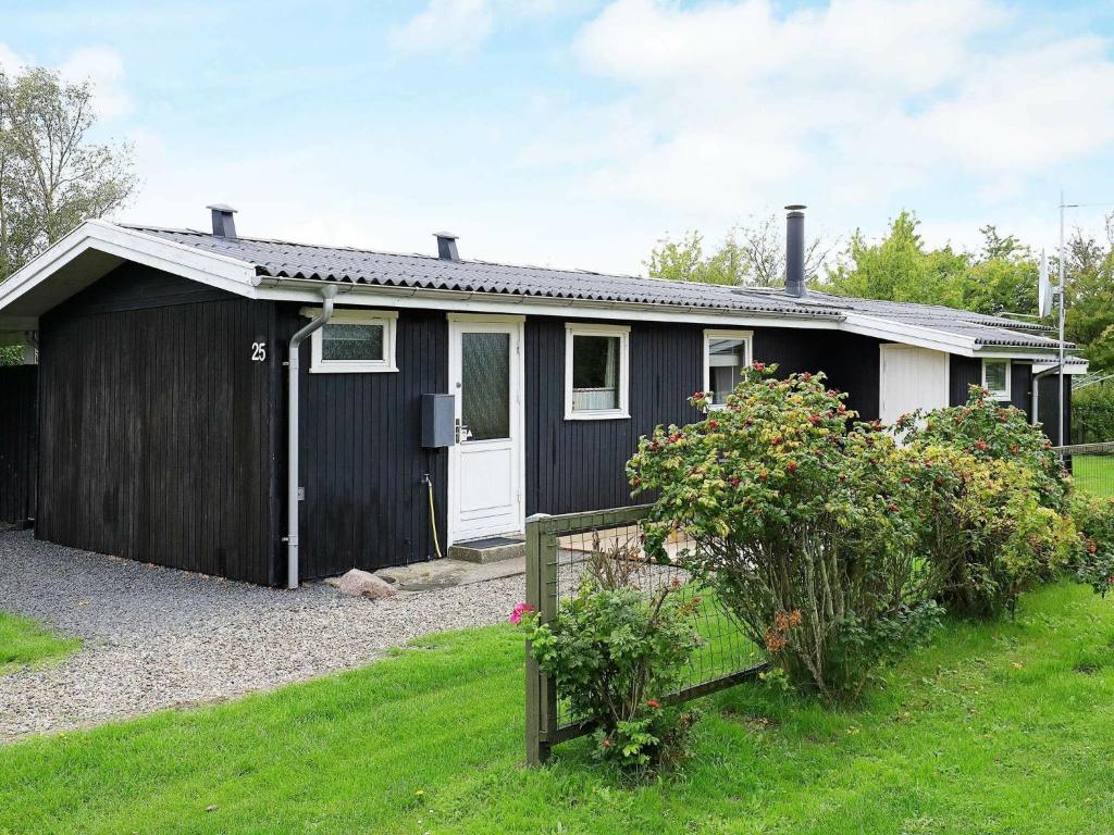 ein Schwarz-Weiß-Haus mit Garten in der Unterkunft 6 person holiday home in Dannemare in Dannemare