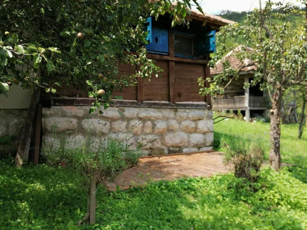 una casa con una pared de piedra y un árbol en Плави вајат 