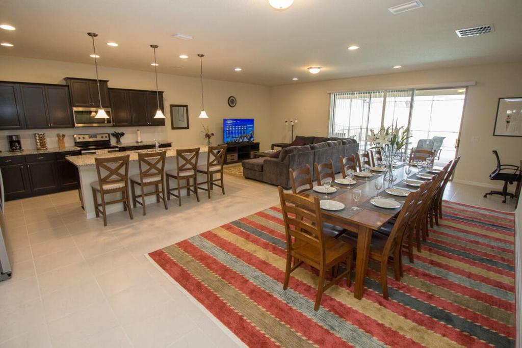 a large living room with a table and a kitchen at Large Luxury Home Pool Home in Kissimmee