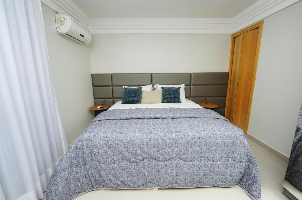 a bedroom with a bed with a blue blanket at Hotel Saint Louis in Luís Eduardo Magalhães