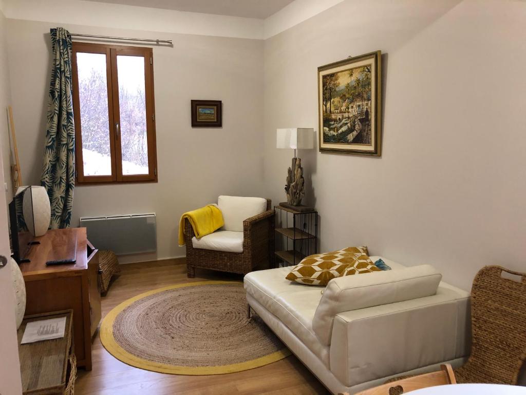 a living room with a couch and a chair at Le Vieux Moulin in Forcalquier