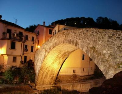 a stone bridge over a river in a city at Casina Matilde in Varese Ligure