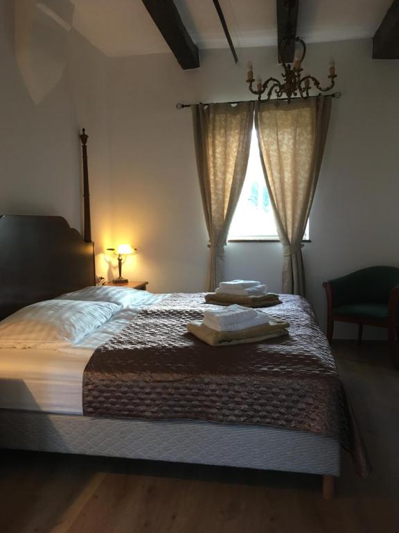 1 dormitorio con 1 cama con toallas en Jókai Vendégház Homokkomárom, en Homokkomárom