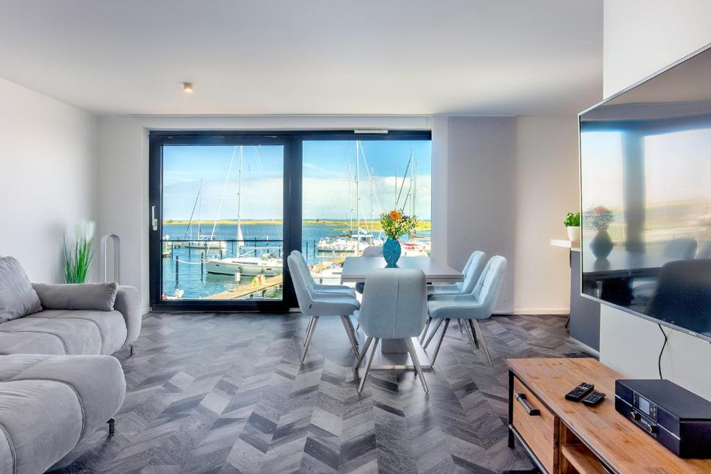 a living room with a table and chairs and a large window at Stressless in Heiligenhafen