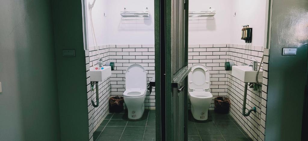 a bathroom with two toilets and two sinks at M House in Hualien City