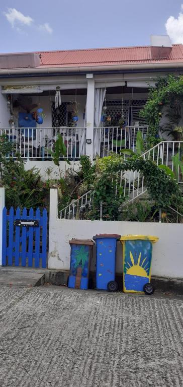 a house with two trash cans in front of it at Chambre d'hôte la Calebasse in Sainte-Anne