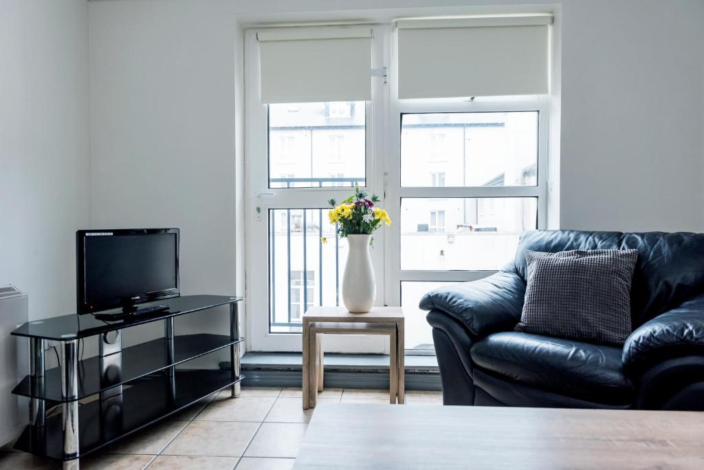 a living room with a couch and a vase of flowers at Marine Court in Bundoran
