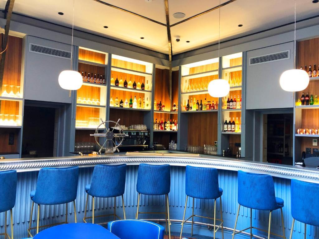 a swimming pool with blue bar stools at L'Eautel Toulon Centre Port in Toulon