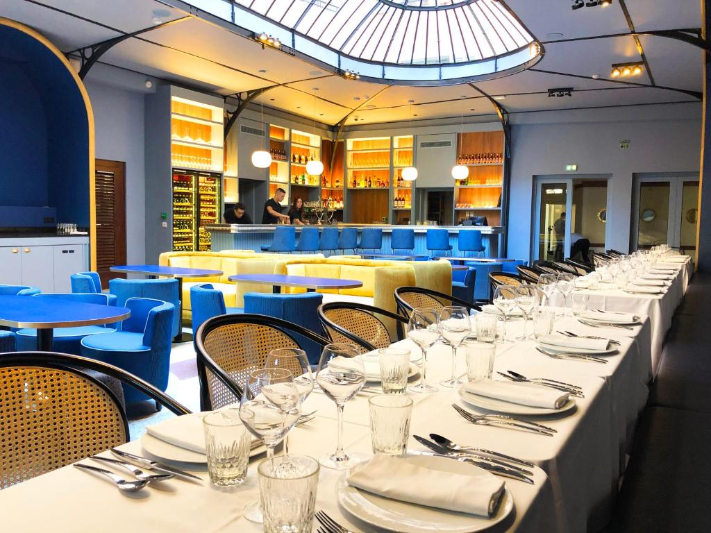 a dining room with white tables and blue chairs at L'Eautel Toulon Centre Port in Toulon