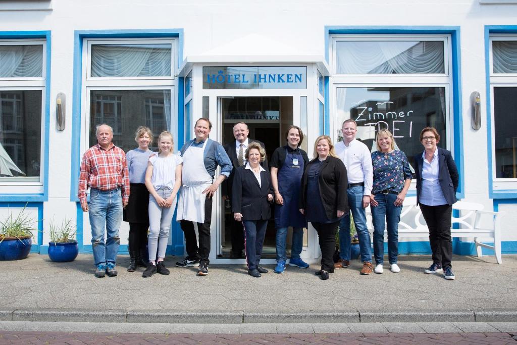 un grupo de personas de pie en frente de una tienda en Inselhotel Ihnken en Norderney