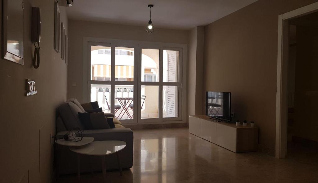 salon z kanapą i telewizorem w obiekcie Stylish apartment in Portofino, near the beach and bars w Almerimar