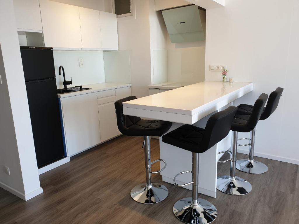 cocina con encimera blanca y electrodomésticos negros en James Sun Beach Apartment, en Ostende