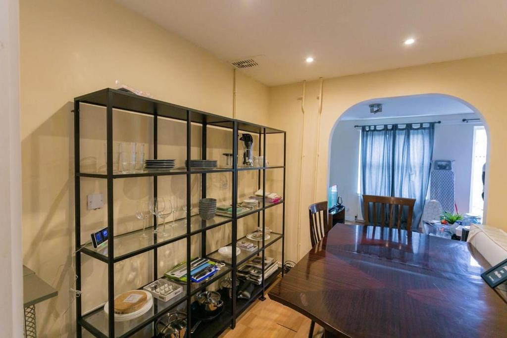 a dining room with a glass shelf with dishes at TownHouse4bedRoomHouse in West Dulwich