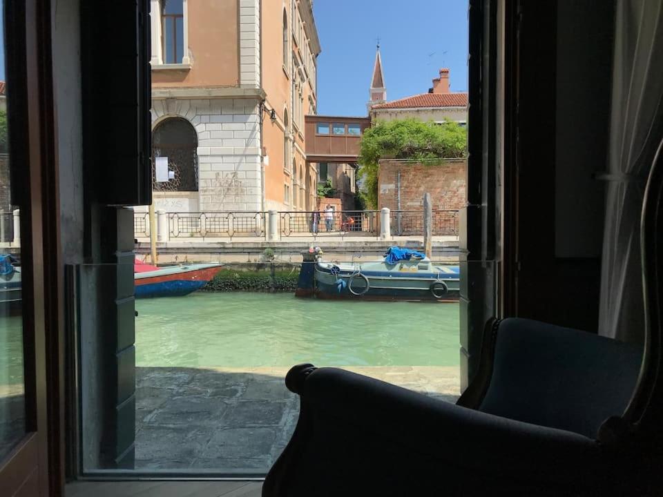 a view from a window of a canal with a boat at Canal view apartment in Venice