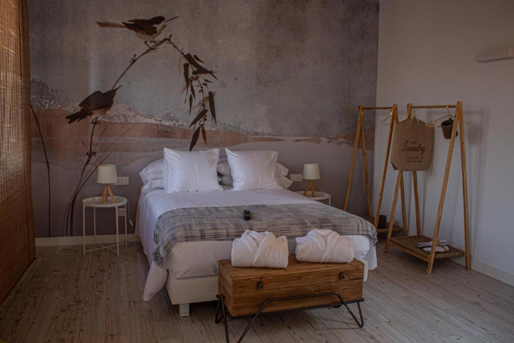 1 dormitorio con 1 cama con pájaros en la pared en La Casa Del Miracle, en Balaguer