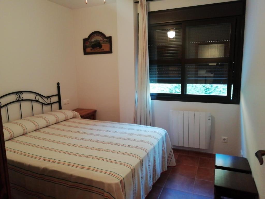 Schlafzimmer mit einem Bett und einem Fenster in der Unterkunft Puerto Lorente in Cazorla