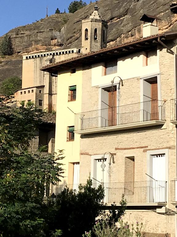 un edificio antiguo con una colina en el fondo en Casa Oliván, en Graus