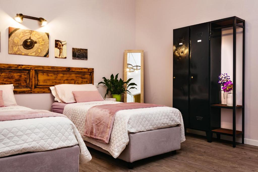 クレモナにあるB&B La Biciclettaのベッドルーム1室(ベッド2台、鏡付)