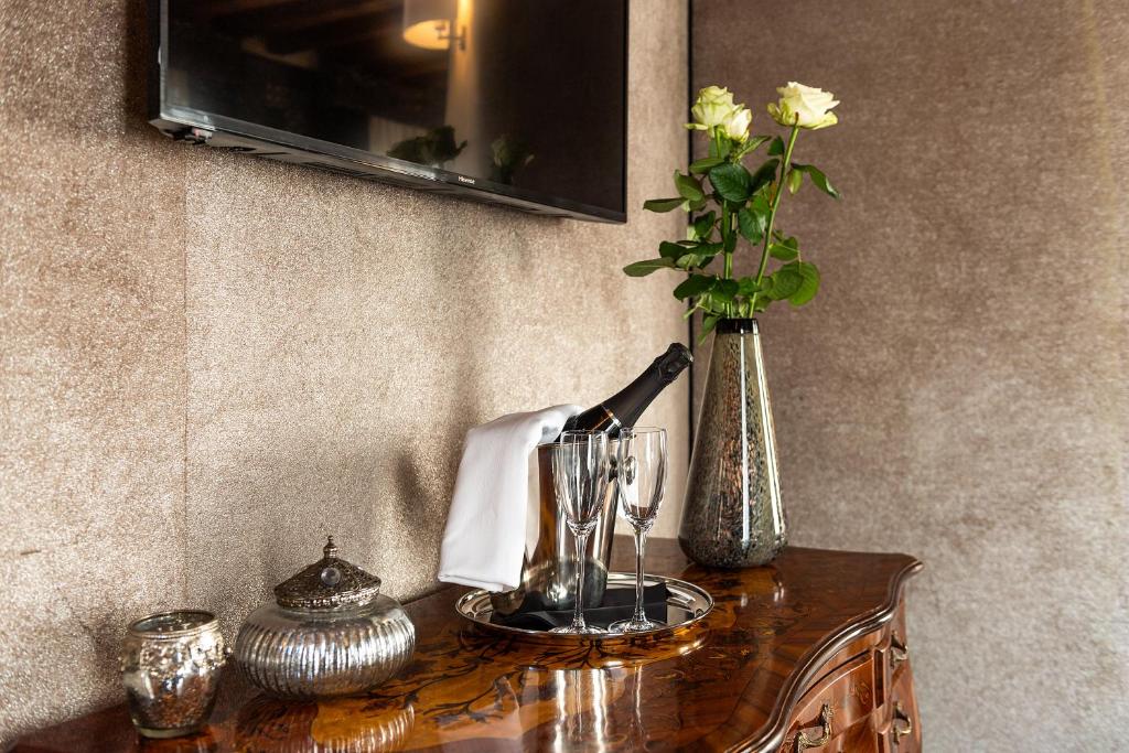 a table with a bottle of wine and a vase with flowers at Domus Superior in Venice