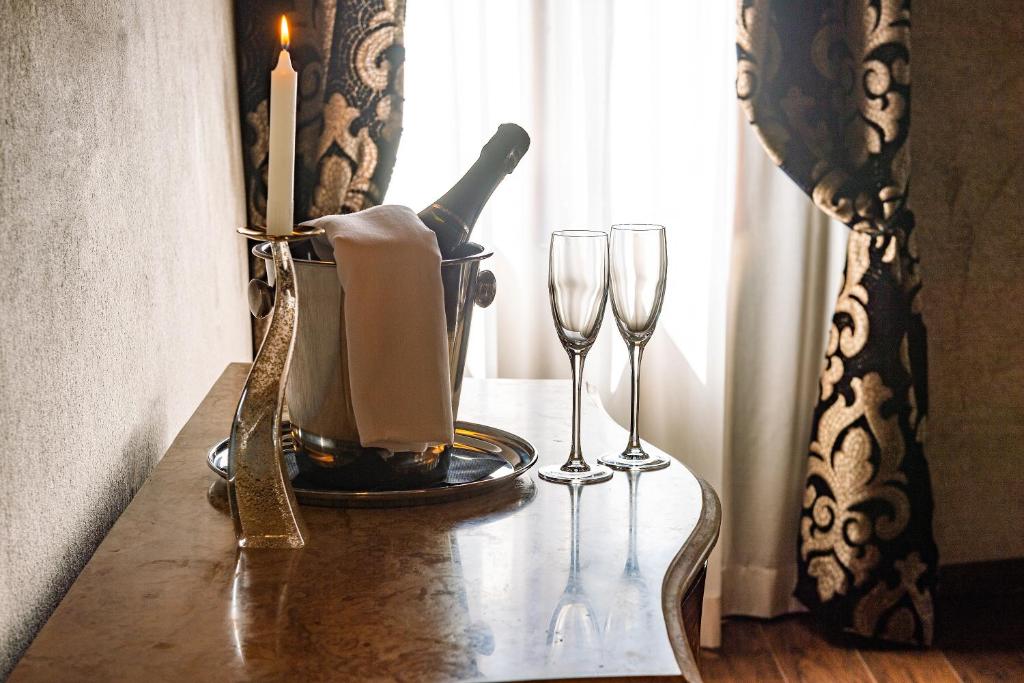 a table with a bottle of wine and two glasses at Domus Superior in Venice