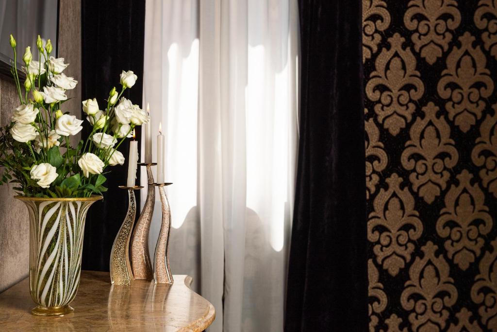two vases with flowers on a table next to a window at Domus Superior in Venice