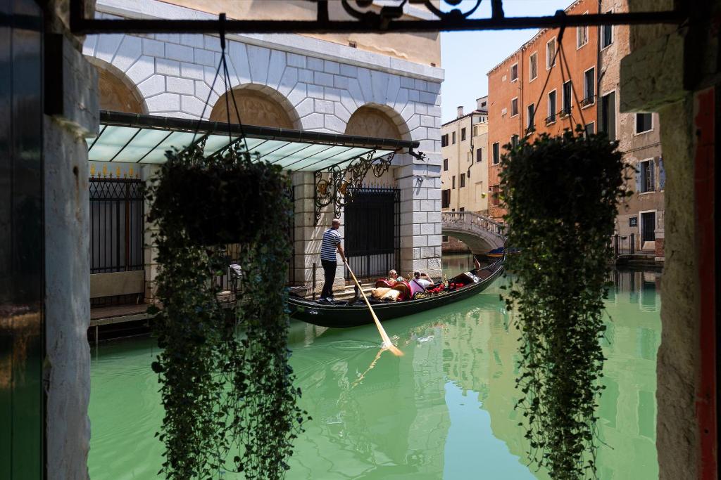 a man is paddling a gondola down a canal at Domus Superior in Venice