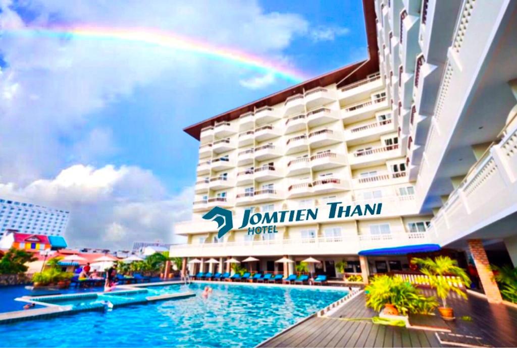 a rainbow over a hotel with a swimming pool at Jomtien Thani Hotel in Jomtien Beach