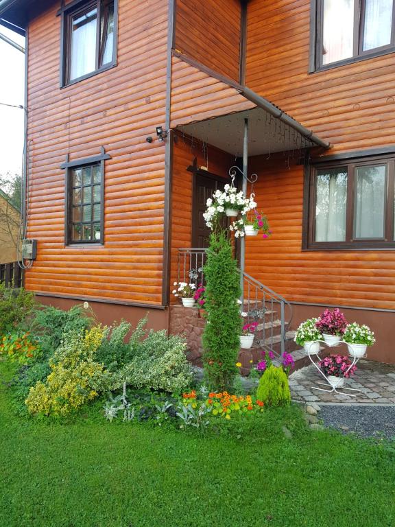 een huis met een bos bloemen ervoor bij U Tetyany in Slavske