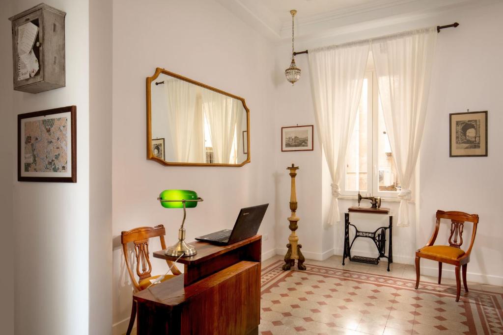 um quarto com uma secretária com um computador portátil e um espelho em Guesthouse Serafino em Roma