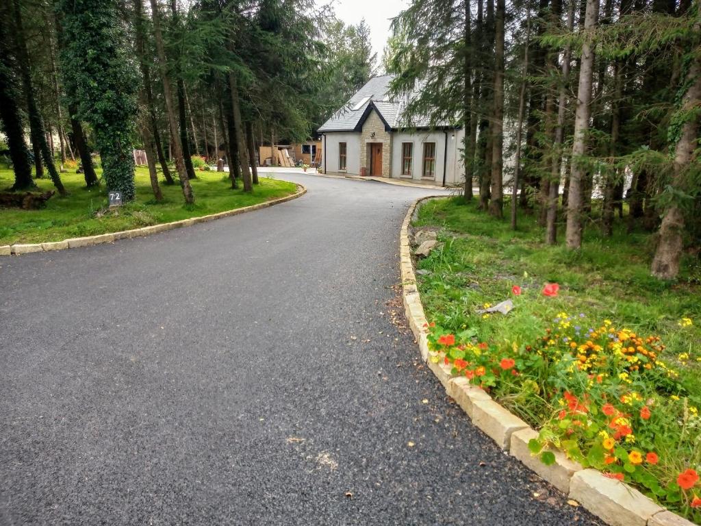 a road in front of a house with flowers at Pigeon Brae pet friendly accommodation Enniskillen in Enniskillen