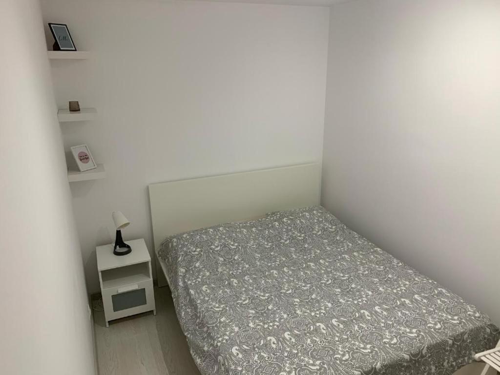 um pequeno quarto com uma cama e uma mesa de cabeceira em Apartment Pitesti em Piteşti
