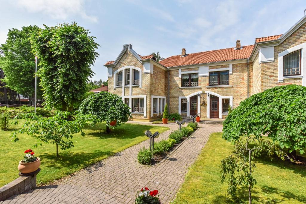 una imagen de una casa con jardín en Villa Leonardo, en Ventspils