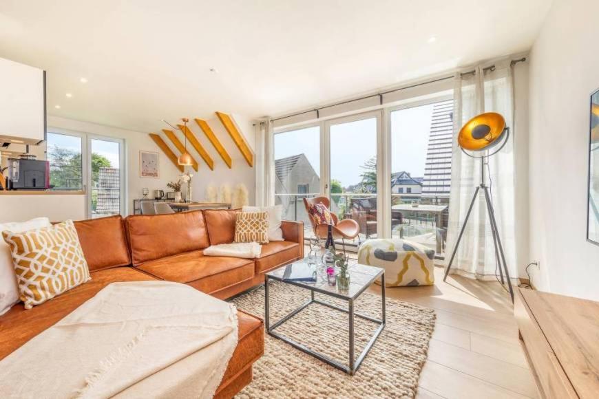 una sala de estar con un sofá y una mesa en Suite Windrose, en Zingst