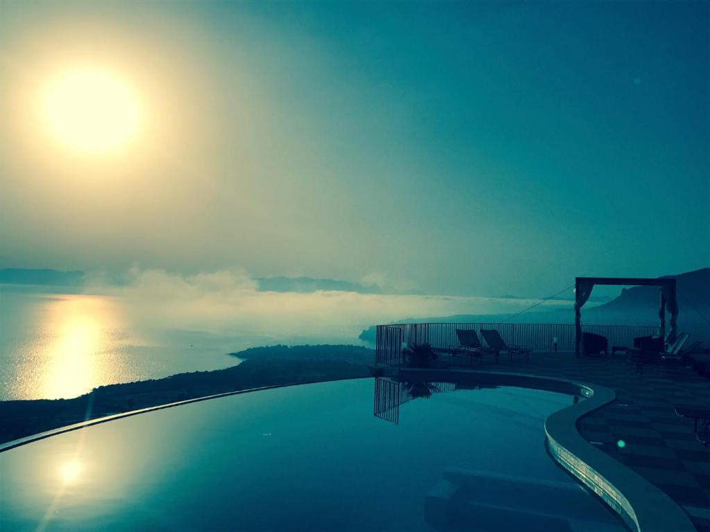 a swimming pool with a view of the water at Hotel Antica Cascina Del Golfo in Scopello