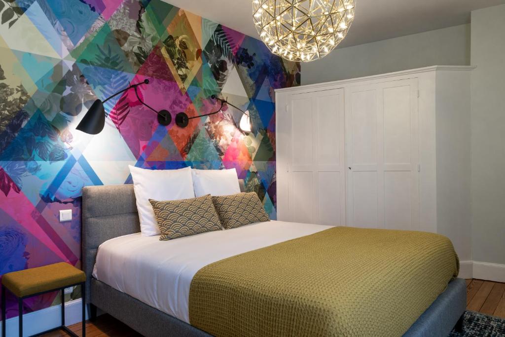 ein Schlafzimmer mit einem Bett und einer farbenfrohen Wand in der Unterkunft Le Leon Bourgeois 6 pers Hypercentre Epernay in Épernay