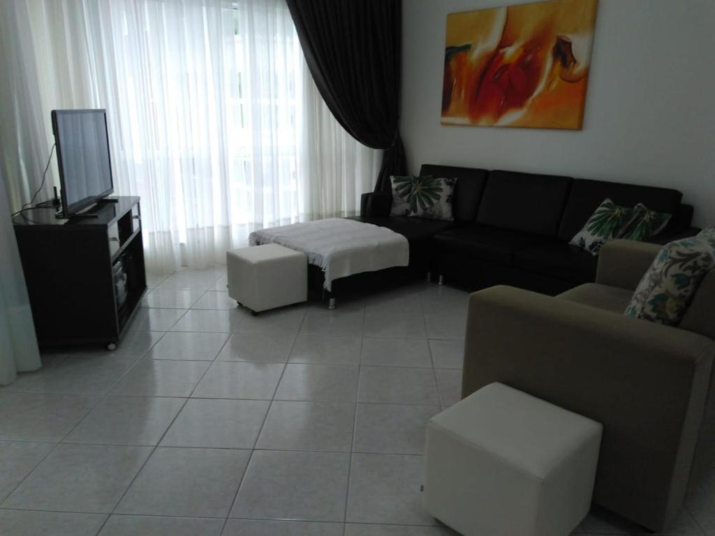 sala de estar con sofá y TV en 3 dorms com vista a 250 mts do mar no centro da Meia Praia Itapema, en Itapema