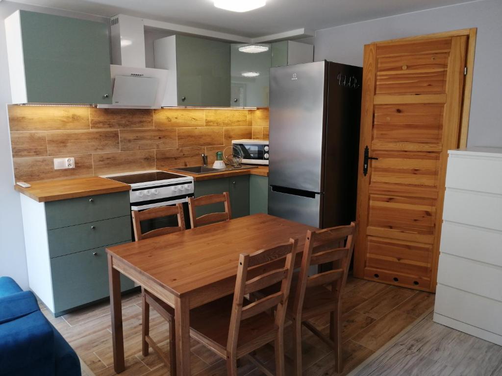 a kitchen with a wooden table and a refrigerator at Gościniec filmowy - prywatny dom rodzinny in Warsaw