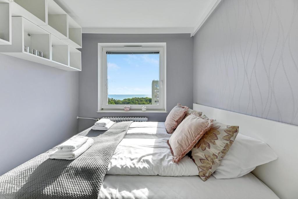 sypialnia z dużym łóżkiem i oknem w obiekcie Comfort Apartments Wyspiańskiego w mieście Gdynia