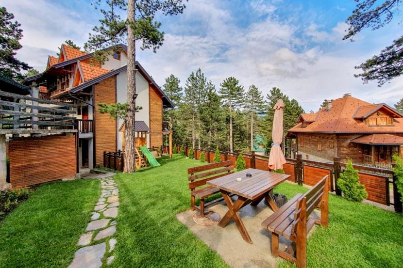 a backyard with a picnic table and a house at Simic Apartmani Tara in Kaludjerske Bare