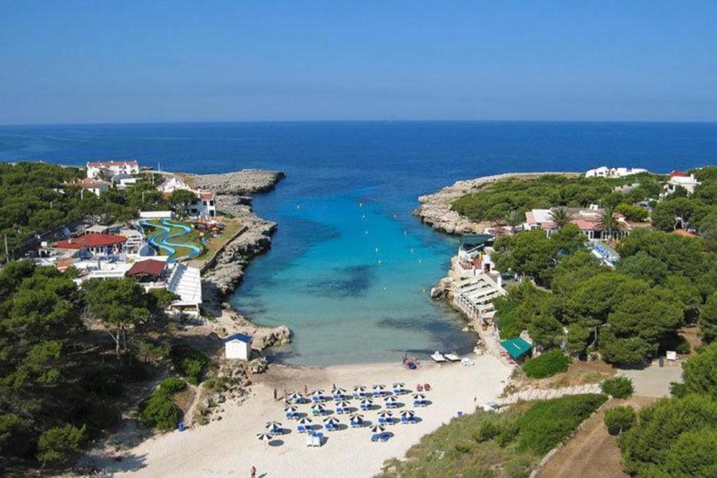 an aerial view of a beach with a group of chairs at Menurka - Cala Blanca in Cala Blanca