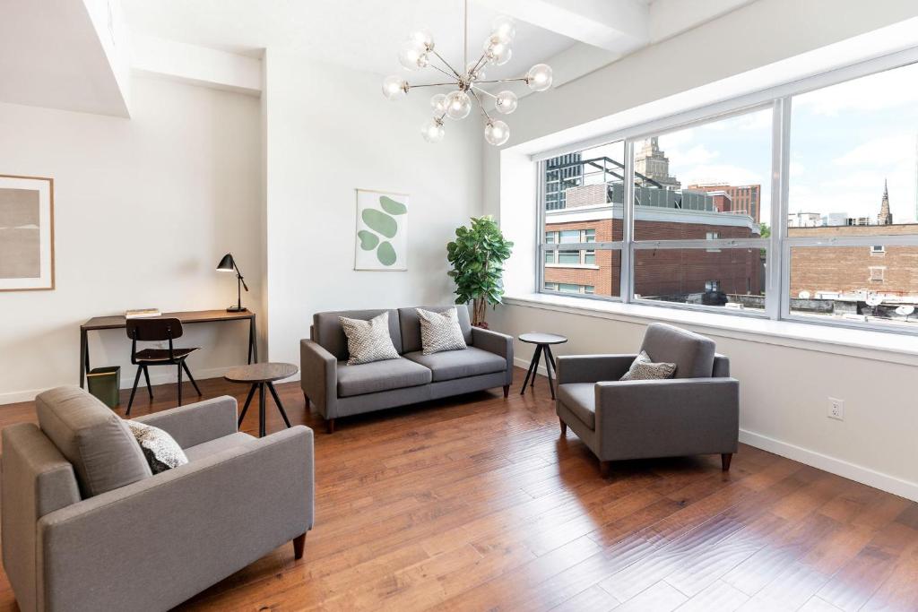 a living room with two couches and a large window at Kislak 402 Spacious 1BR Retreat Above the City in Newark