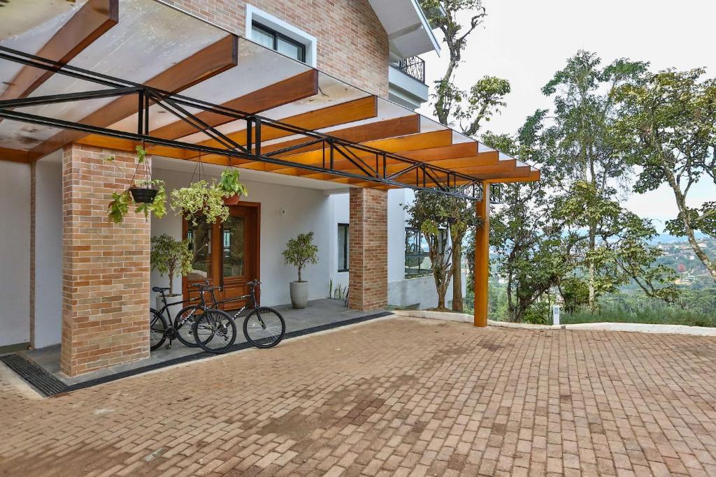 un edificio de ladrillo con una bicicleta estacionada en un patio en Carpe Diem Boutique & Spa - BW Premier Collection en Campos do Jordão