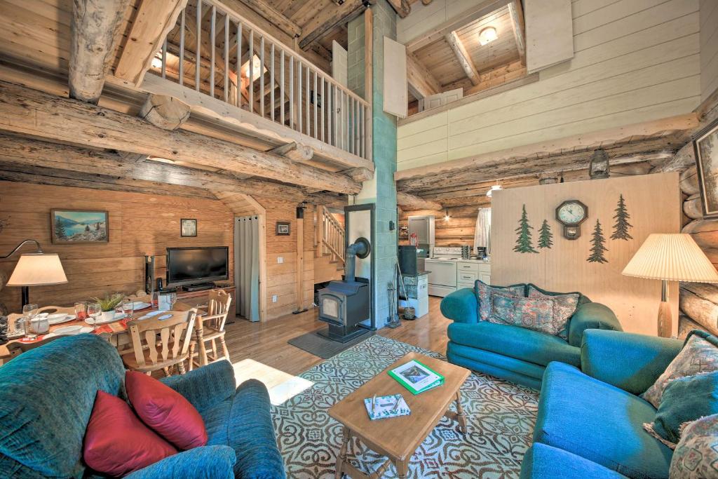 a living room with blue couches and a table at Expansive Moyie Riverfront Cabin - Pets Welcome! in Bonners Ferry