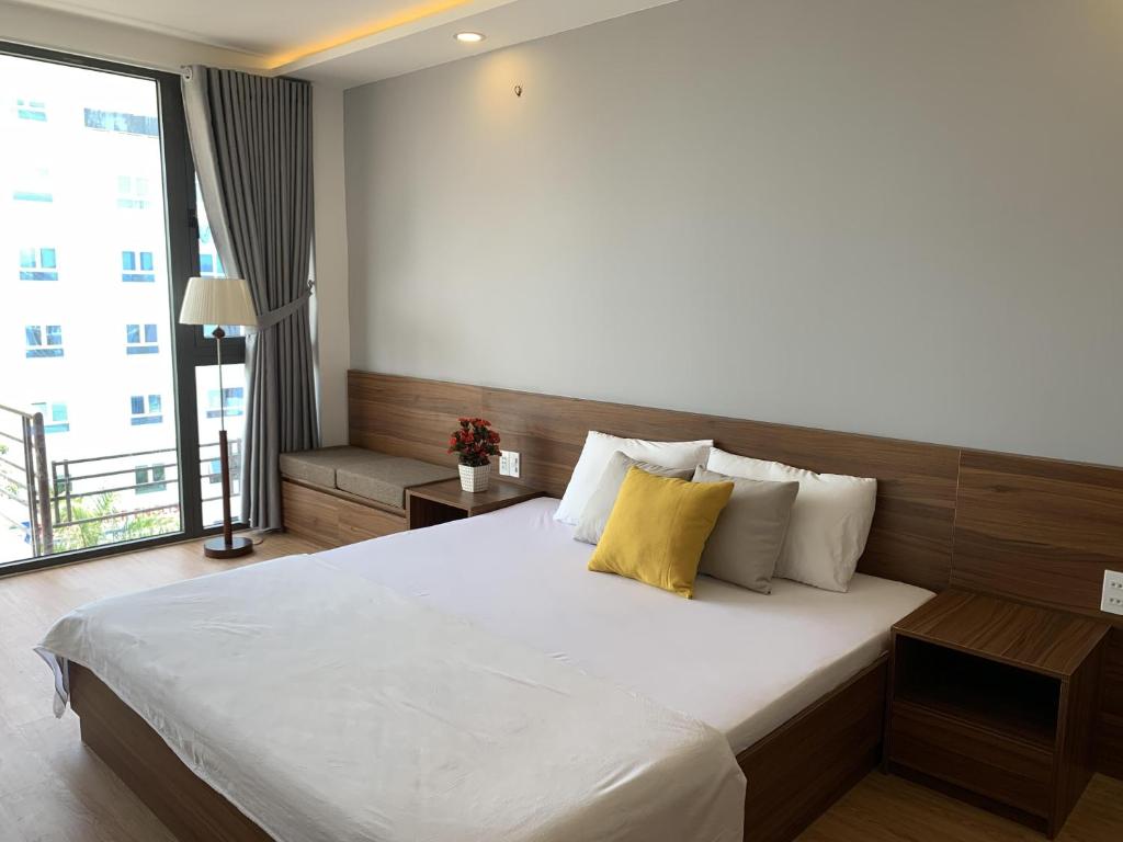 a bedroom with a large bed and a large window at Rang Dong Hue Hotel in Hue