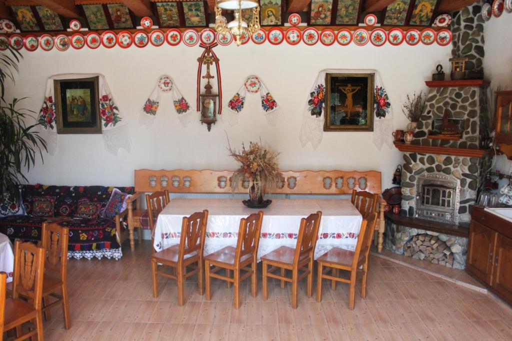 a dining room with a table and a fireplace at ILEANA Săpânța in Săpânța