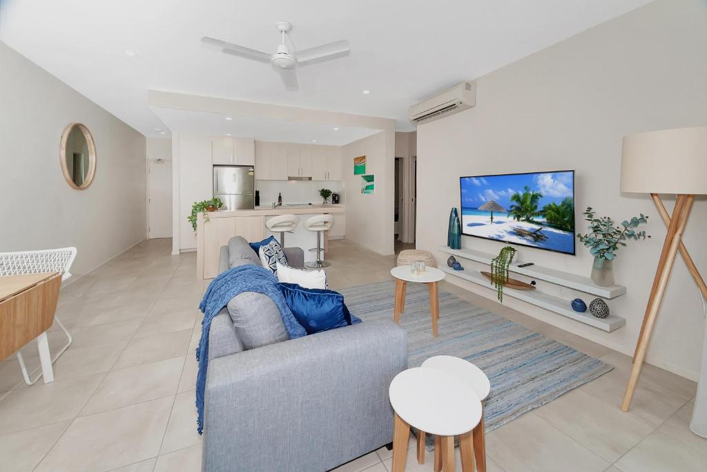 ein Wohnzimmer mit einem Sofa und einer Küche in der Unterkunft Apartment Close to the City Life on Lake 3 in Cairns North