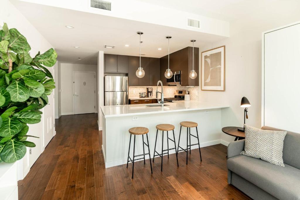 a kitchen and living room with a bar and stools at Kislak 601 1BR Penthouse with Stunning Rooftop Terrace in Newark