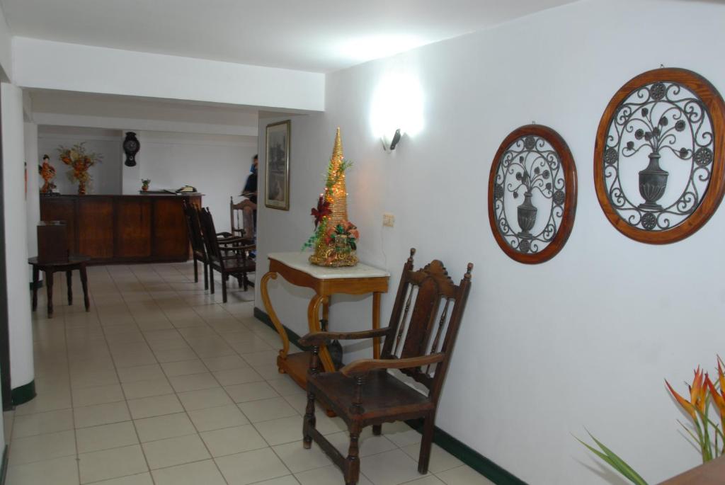 een eetkamer met een kerstboom en borden aan de muur bij Hotel Tiumara Cartago in Cartago
