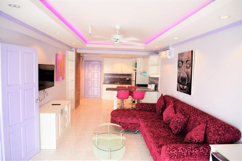 un soggiorno con divano rosso e sedie rosa di Luxury apartment Jomtien beach condominium S1 Pattaya 3rd floor a Jomtien Beach