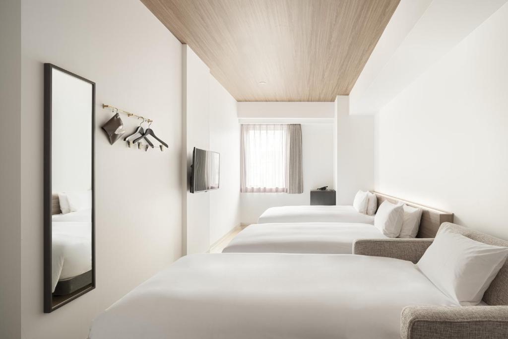 Postel nebo postele na pokoji v ubytování Nest Hotel Hiroshima Ekimae
